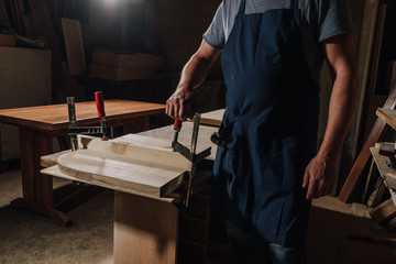 partial view of woodworker standing at wooden workshop