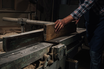 cropped shot of carpenter working with wood at workshop