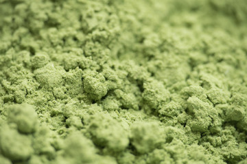 Obraz premium Organic wheatgrass powder background with selective focus