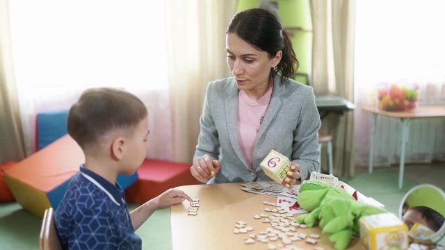 The woman speech therapist and the boy at the therapy session