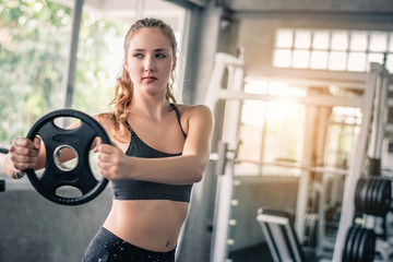 Fototapeta na wymiar Cinematic tone of young attractive fitness woman exercise with machine in gym. 