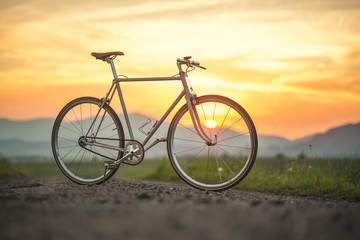 Fototapeta na wymiar Retro bicycle on the road in sunset, detail photography of bike components
