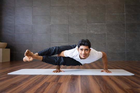 Portrait of man practicing yoga and standing on hands