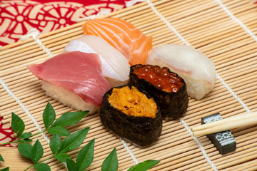 sushi set on white bamboo sheet with chopsticks