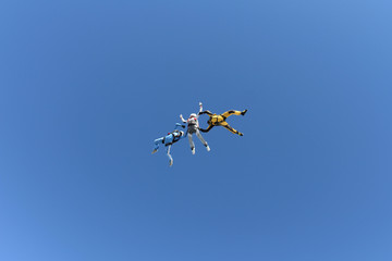 Skydiving. Two instructors are training a student to fly.
