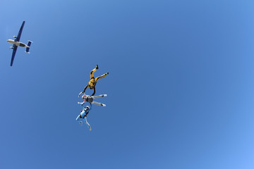 Skydiving. Two instructors are training a student to fly.