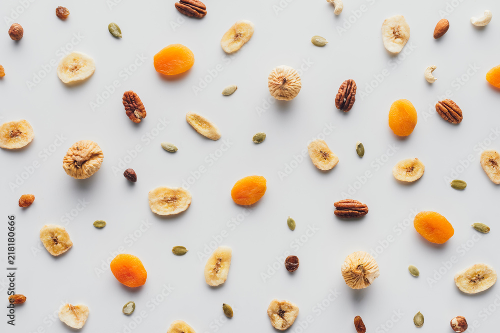 Wall mural top view of tasty dried fruits and nuts isolated on white background