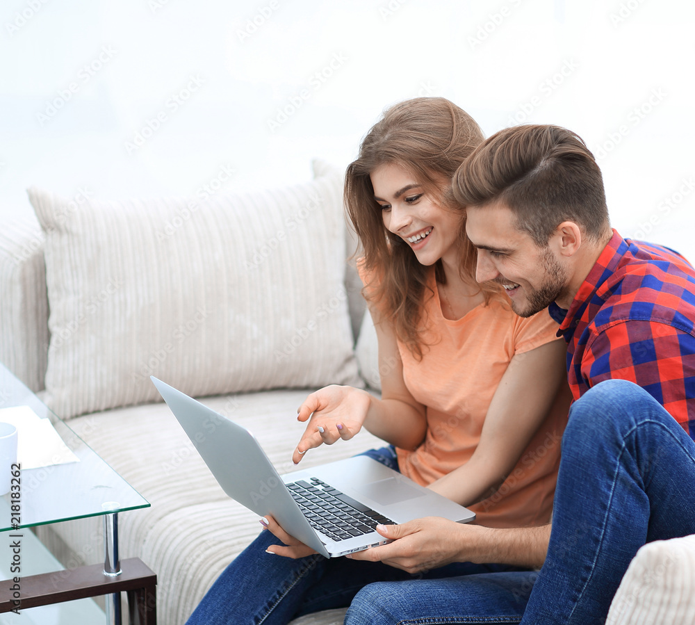 Wall mural young couple watching videos on laptop