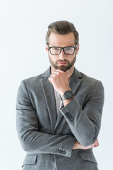 thoughtful businessman in eyeglasses and gray suit with wristwatch on hand, isolated on white