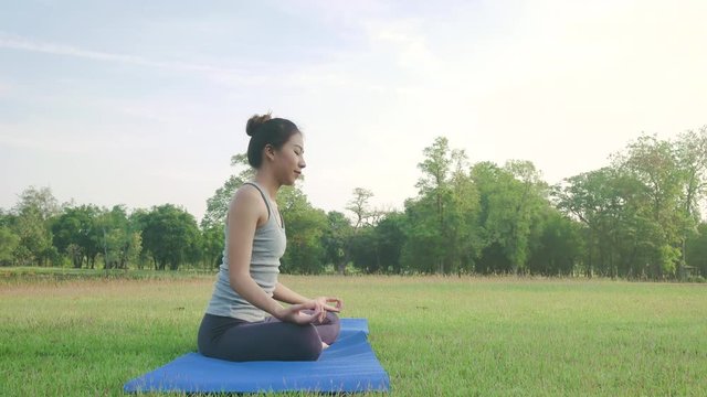 Young asian woman yoga outdoors keep calm and meditates while practicing yoga to explore the inner peace. Yoga and meditation have good benefits for health. Yoga Sport and Healthy lifestyle concept.