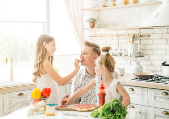 dad with daughters preparing pizza
