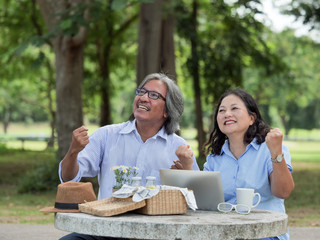 Happy Senior couple picnicking in the garden home.