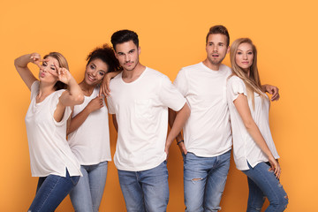 Group of beautiful friends posing together in studio.