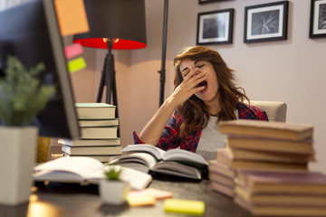 Tired woman yawning at her desk