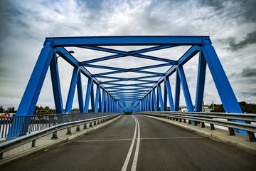 Foto op Plexiglas Blue metal bridge with clouds in the background. © Kozioł Kamila