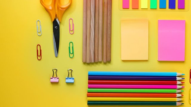 Back To School Text on Torn Paper. School Stationary Flat Lay on Yellow Background Timelapse 4K