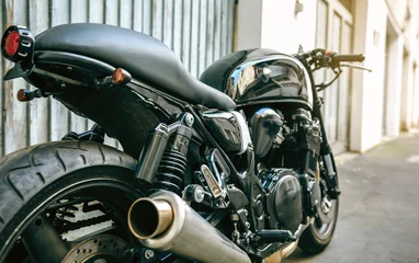 Photo sur Plexiglas Moto Vue arrière d& 39 une moto personnalisée garée devant la porte du garage