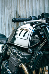 Detail of engine and gas tank of customized motorcycle parked in front of garage door