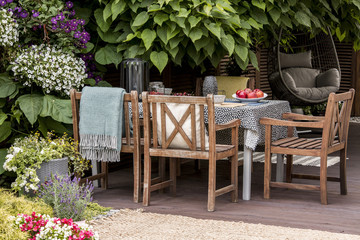 Real photo of garden furniture on beautiful terrace full of flowers and plants