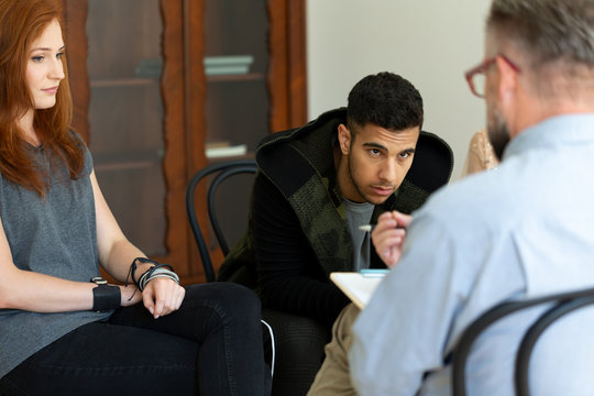 Multicultural group of people talking with counselor about problems