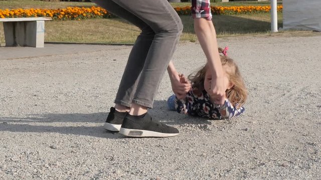 Little Girl fell down hit the Ground and Mother getting up her Daughter on Legs
