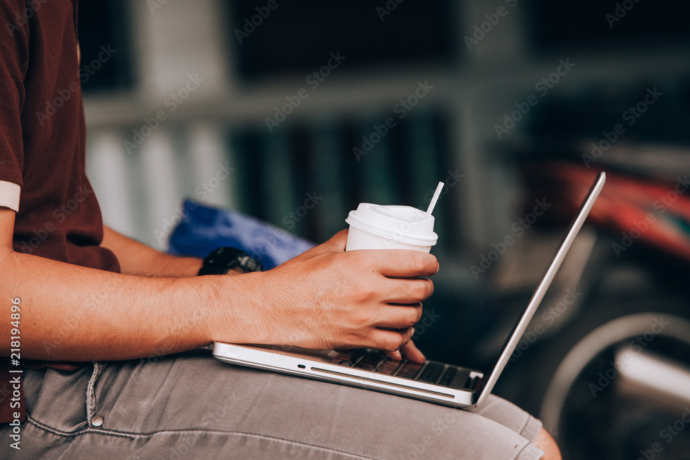 Wall mural man is working by using a laptop computer on vintage wooden table. Hands typing on a keyboard. Top view.