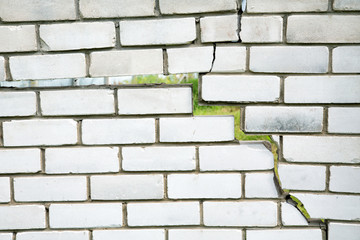crack in the fence of gray bricks on a summer day