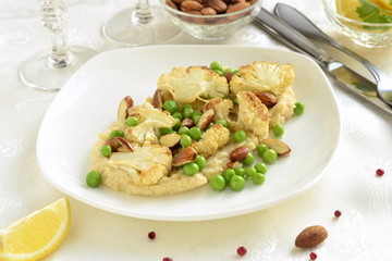 Salad with roasted cauliflower and green peas, almonds served on vegetable puree
