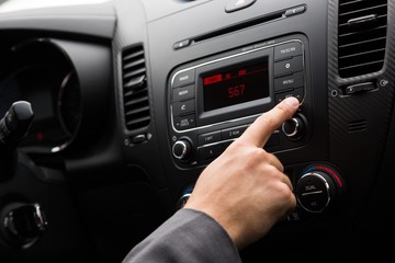 Closeup of a Hand Pressing a Button of a Car Audio System