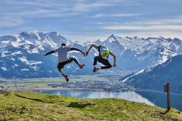 Naklejka na ściany i meble Men jumping from the peak in Alps