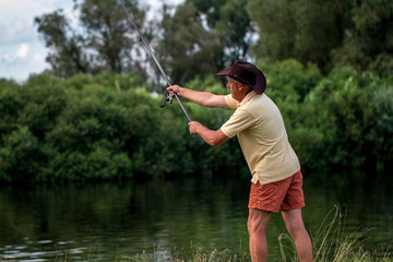 The fisherman throws the fishing rod into the water. Fishing