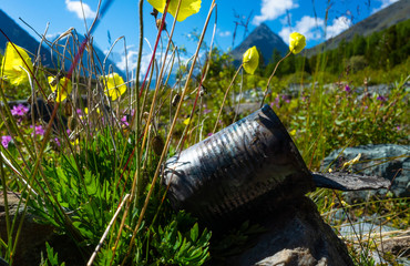 Fototapeta premium discarded can of canned food on the background of the mountain landscape