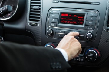 Closeup of a Hand Pressing a Button of a Car Audio System