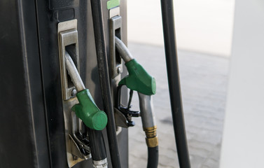 Close up on dirty fuel nozzle in oil dispenser with gasoline and diesel in service gas station....