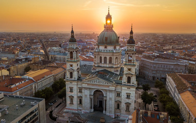Fototapeta na wymiar Budapest, Hungary - The rising sun shining through the tower of the beautiful St.Stephen's Basilica (Szent Istvan Bazilika) at sunrise on an aerial shot