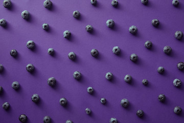 pattern of ripe blueberries on violet surface