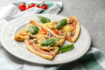 Plate with slices of tasty pizza on table