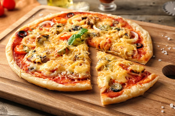 Tasty pizza on wooden board, closeup