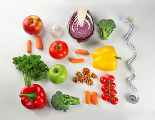 Flat lay composition with diet food and measuring tape on white background