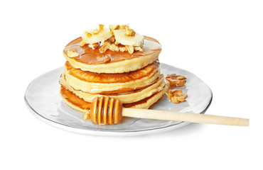 Plate with tasty pancakes, walnuts and sliced banana on white background