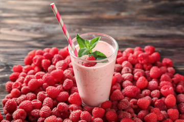 Glass with tasty raspberry smoothie on wooden table