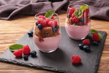Glasses with tasty raspberry dessert on table