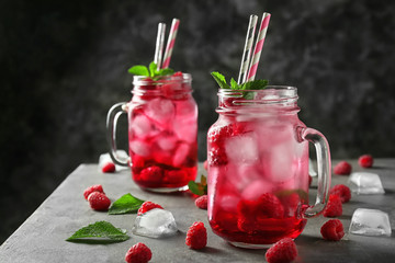 Mason jars of fresh raspberry mojito on table
