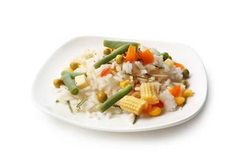 Plate with tasty boiled rice and vegetables on white background