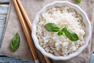 Bowl with boiled white rice on table