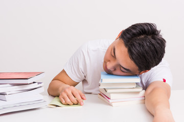 Tired young man sleeping on table.