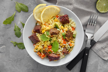 Delicious boiled rice with meat and vegetables in bowl on table