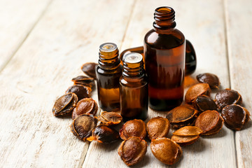 Bottles with apricot essential oil on wooden table