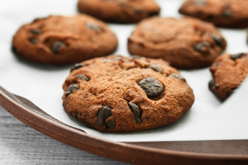 Plate with tasty chocolate cookies on table, closeup