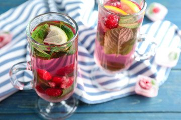 Glasses of fresh raspberry mojito on wooden table